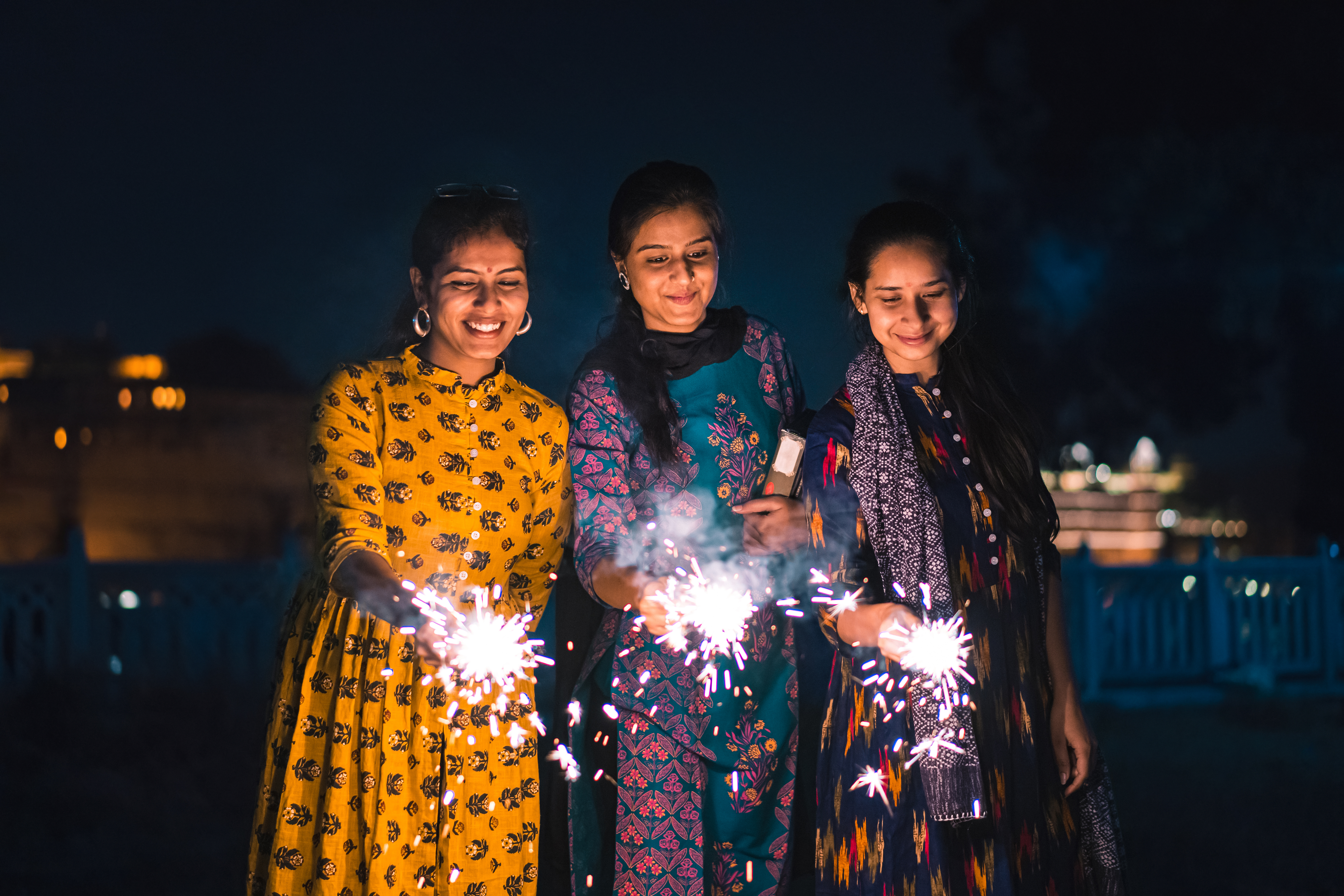 Three young Indian women with bengal fireworks, Udaipur, India